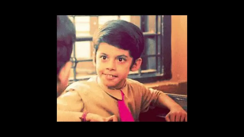 A grinning boy in a film still